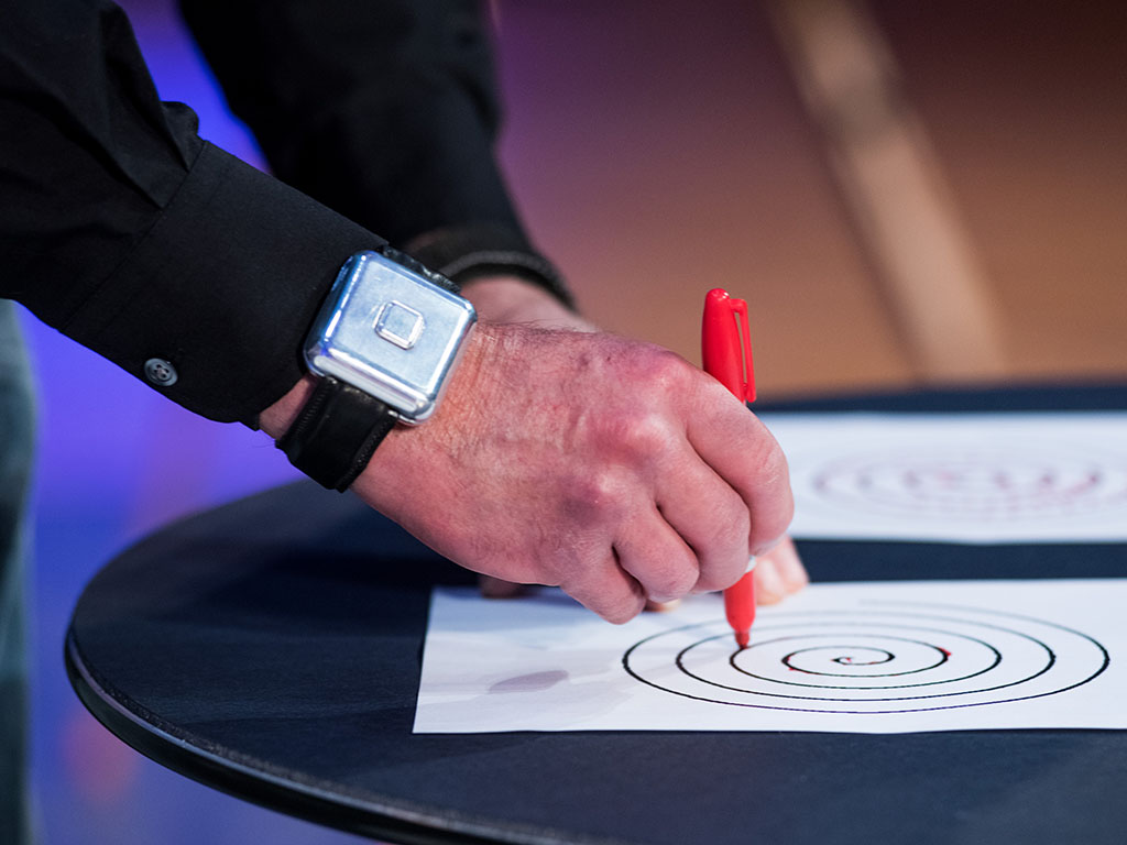 hand holding a market tracing over circles on a sheet of paper