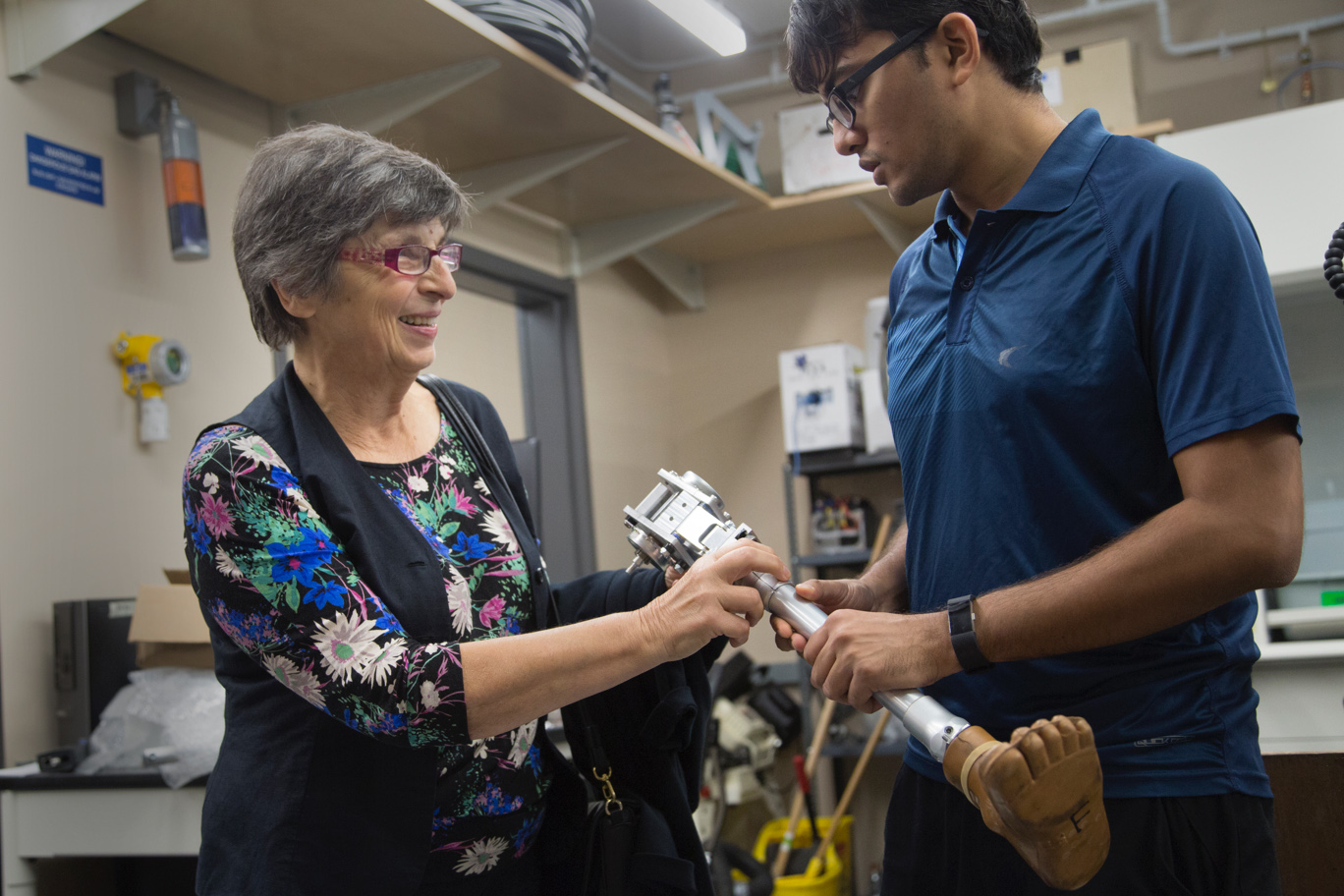 Two people holding a prosthetic leg.